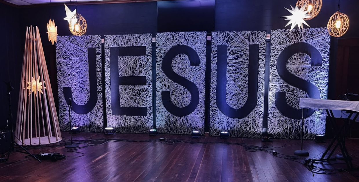 An empty stage with the word Jesus in the background